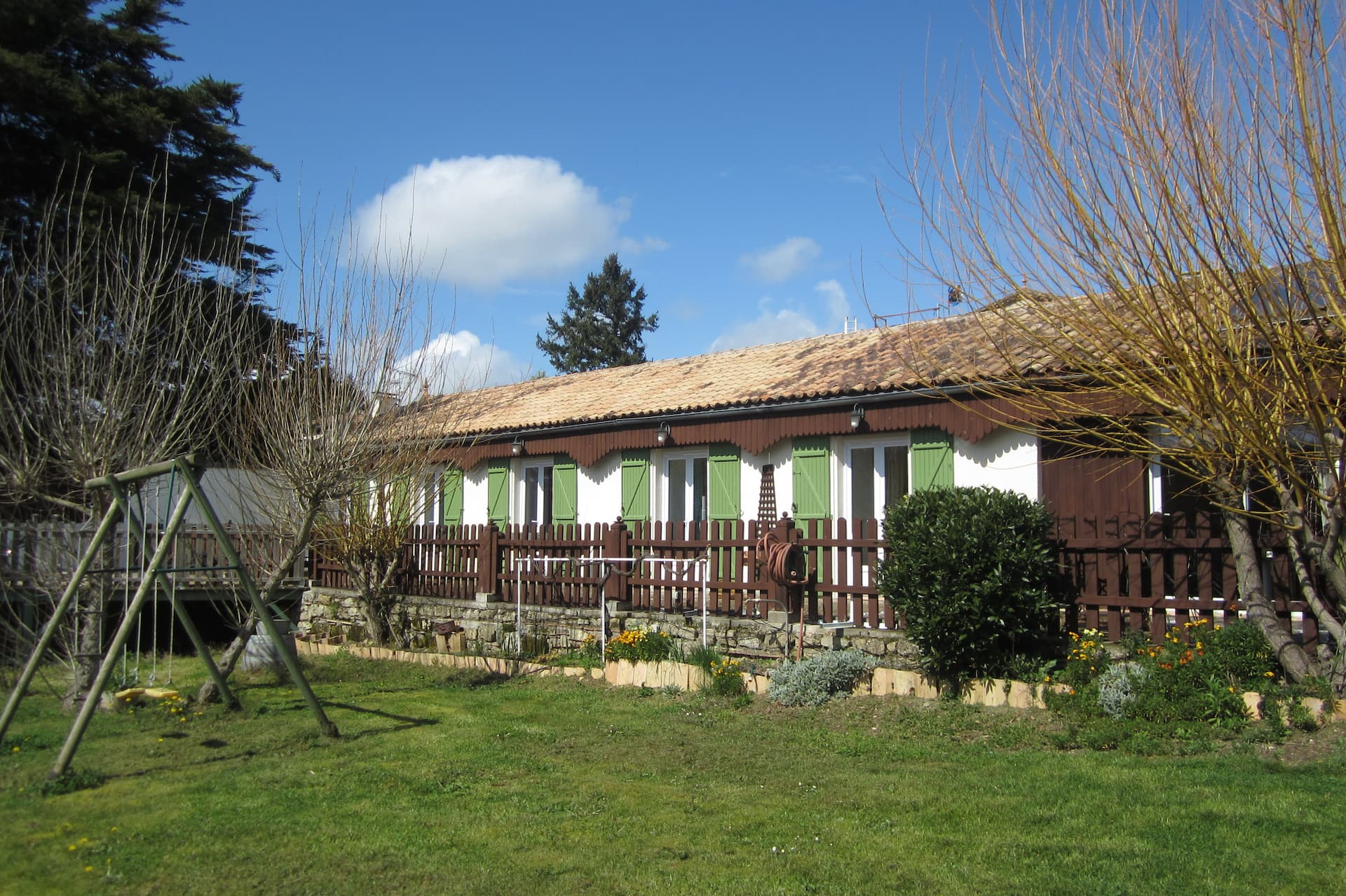 Le jardin arboré du gîte, avec sa balançoire et son terrain de pétanque